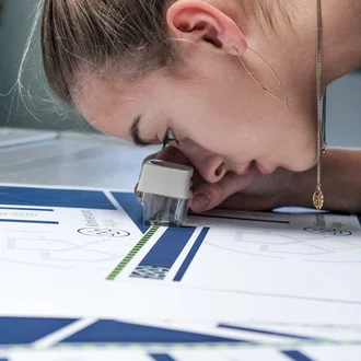 Prüfung von Druckmustern für das Corporate Design des Klinikverbunds Allgäu mit einem Fadenzähler