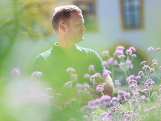 Christian Schoch zwischen Blumen und Grünanlage in Kempten