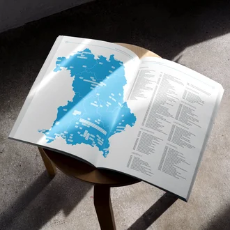 Aufgeschlagene Broschüre mit einer Übersichtskarte von Bayern und einer tabellarischen Auflistung regionaler Klinikstandorte – visuelle Darstellung der Mitgliederstruktur des VPKA (Verband der Privatkliniken in Bayern e. V.) zur geografischen Verteilung von Gesundheitseinrichtungen.