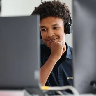 Denkströme Mitarbeiter mit Headset arbeitet konzentriert am Bildschirm im Büro – Szene aus der Website-Entwicklung und technischen Umsetzung.