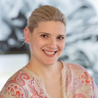 Porträt von Denkströme Geschäftsführerin Teresa Weber, lächelnd vor kreativem Agentur-Hintergrund