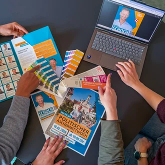 Kampagnenmaterial für Christian Schoch mit Flyern, Plakaten, Farbfächern und Laptop