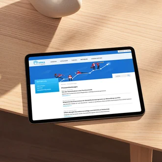 Tablet auf einem Holztisch mit geöffneter Webseite des VPKA – Verband der Privatkliniken in Bayern e. V. – im Bereich „Pressemitteilungen“, darunter Artikel zu Psychosomatik, Post-COVID-Reha und gesundheitspolitischen Entwicklungen – digitale Öffentlichkeitsarbeit im Gesundheitswesen.