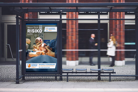 Großflächenplakat des Allgemeinen Krankenhauses Celle mit Neugeborenem im OP-Saal, Slogan „Wenn dich das Risiko trifft!“ und Hinweis auf das Perinatalzentrum Level 1