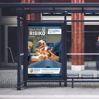 Großflächenplakat des Allgemeinen Krankenhauses Celle mit Neugeborenem im OP-Saal, Slogan „Wenn dich das Risiko trifft!“ und Hinweis auf das Perinatalzentrum Level 1