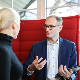 Gespräch zwischen Denkströme Geschäftsführerin und Geschäftsführer in moderner Bürolounge – professioneller Austausch über Strategie oder Projektplanung