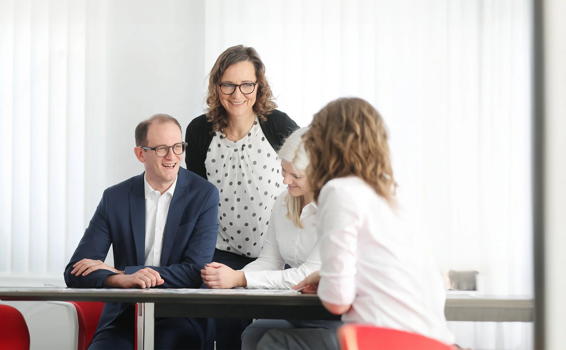 Fröhliches Teammeeting bei der Denkströme mit Fokus auf Zusammenarbeit und moderner Unternehmenskultur