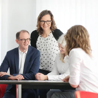 Fröhliches Teammeeting bei der Denkströme mit Fokus auf Zusammenarbeit und moderner Unternehmenskultur