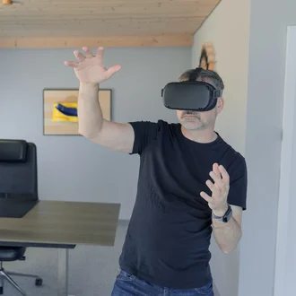 VR-Anwendung bei Denkströme: Mann mit Virtual-Reality-Brille in einem modernen Büro
