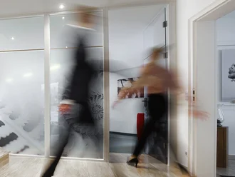 Heller Eingangsbereich mit moderner Holztreppe und Glasfront im Bürogebäude der Denkströme – Businessumgebung mit Bewegung und Dynamik