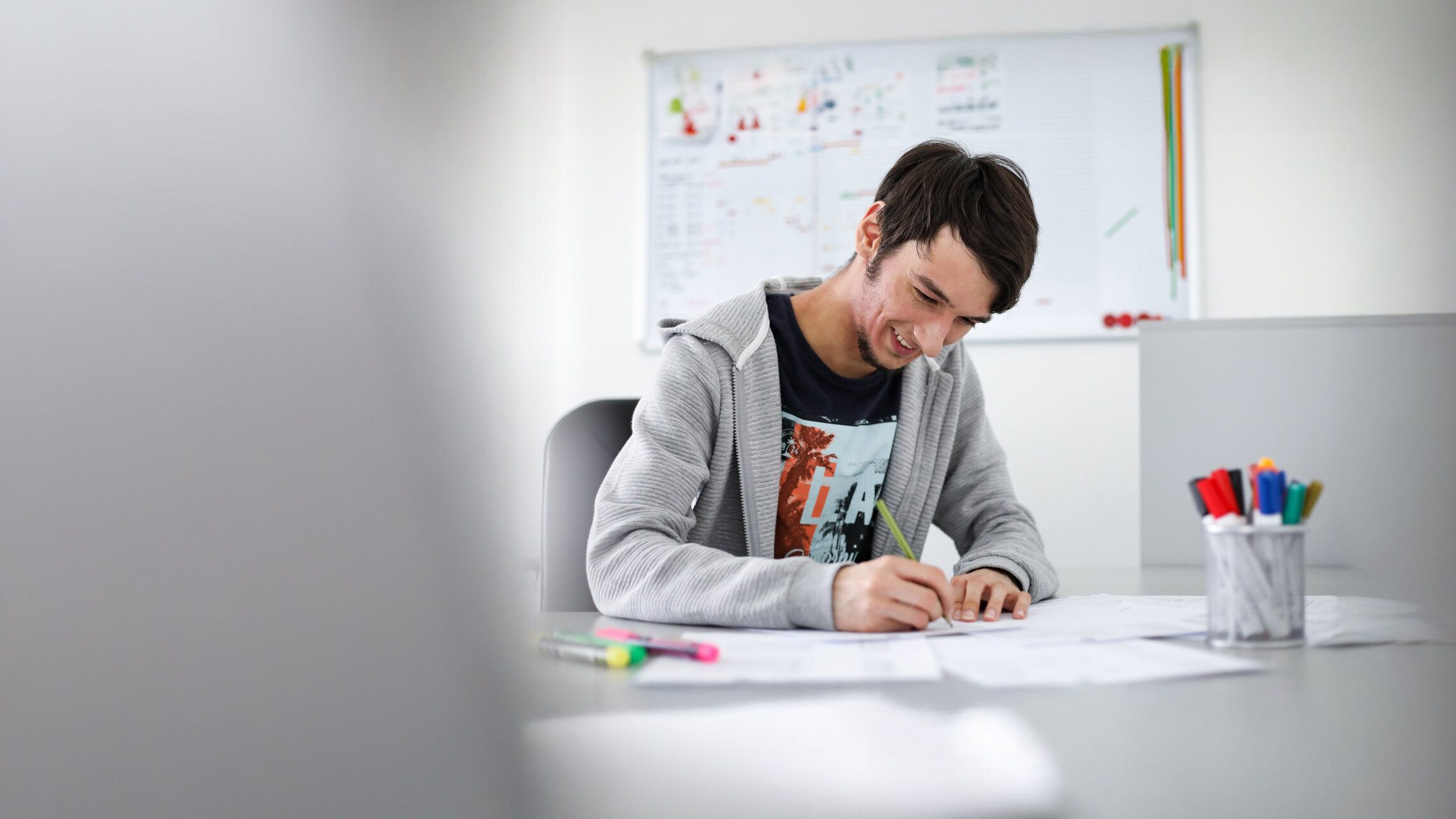 Junger Denkströme Grafiker arbeitet konzentriert an Markenentwürfen im kreativen Büro der Denkströme Gruppe