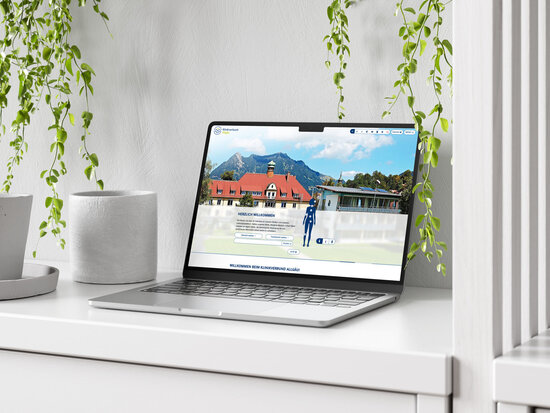 Startseite des Klinikverbund Allgäu auf einem Laptop mit interaktivem Körperkompass vor Alpenkulisse; digitale Orientierungshilfe zu Fachbereichen und Standorten der Klinik auf modernem Webinterface.