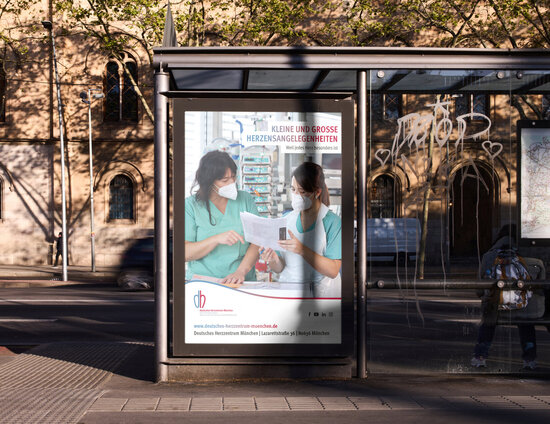 Bushaltestellenplakat des Deutschen Herzzentrums München mit Pflegekräften auf der Intensivstation – Recruiting-Kampagne „Kleine und große Herzensangelegenheiten“ für medizinisches Fachpersonal