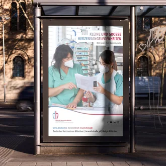 Bushaltestellenplakat des Deutschen Herzzentrums München mit Pflegekräften auf der Intensivstation – Recruiting-Kampagne „Kleine und große Herzensangelegenheiten“ für medizinisches Fachpersonal