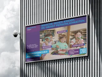 Recruiting-Plakat der Diakonie Allgäu an einer Gebäudefassade mit drei Kindern beim kreativen Spielen in einer Kita