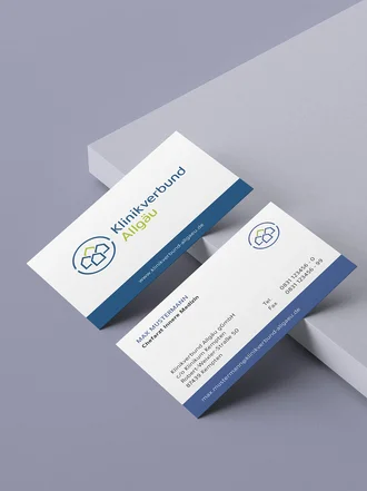 Professionelle Visitenkarten des Klinikverbund Allgäu mit Logo, Kontaktdaten und Corporate Design in Blau-Weiß auf hellem Hintergrund.