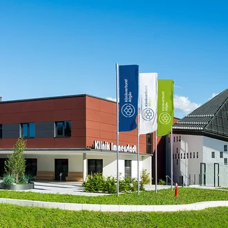 Klinik Immenstadt des Klinikverbunds Allgäu mit Fahnen im neuen blau-grünen Corporate Design