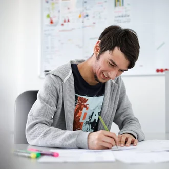 Junger Denkströme Grafiker arbeitet konzentriert an Markendesigns im kreativen Büro der Denkströme Gruppe