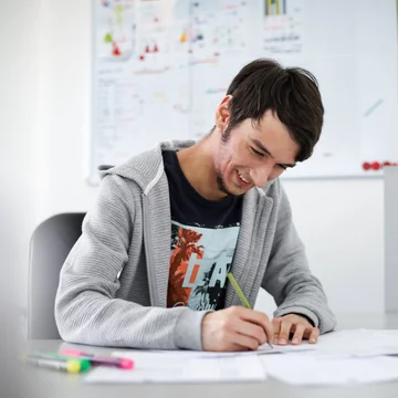 Junger Denkströme Grafiker arbeitet konzentriert an Markendesigns im kreativen Büro der Denkströme Gruppe