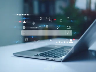 Teilansicht eines Laptops auf einem Schreibtisch, aus dem leuchtende digitale Symbole und Interface-Elemente wie Suchleisten, Herzen, Chatblasen, Kamera-, Cloud- und Nutzer-Icons holografisch hervorgehoben sind