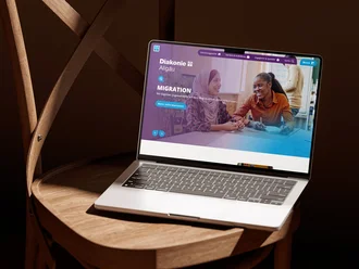 Diakonie-Allgäu-Website auf einem Notebook mit Bereich zum Thema Migration