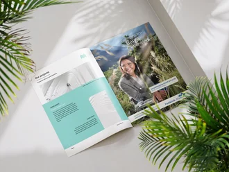 Aufgeschlagene Broschüre mit Recruiting-Anzeige der Fachklinik Allgäu „Gemeinsam Berge überwinden“ neben Projektvorstellung in hellem Setting mit Pflanzen.