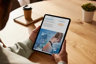 Person hält Tablet mit geöffneter TYPO3-Website des Allgemeinen Krankenhauses Celle – moderner responsiver Webauftritt mit Fokus auf medizinische Leistungen und Patientenservice