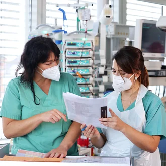 Pflegekräfte des DHZM bei der Dokumentation und Betreuung eines Neugeborenen – moderne High-Care-Medizin mit menschlicher Fürsorge